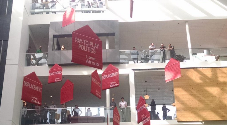 Airbnb protesters fill the company's lobby and create signs based on the company's 
