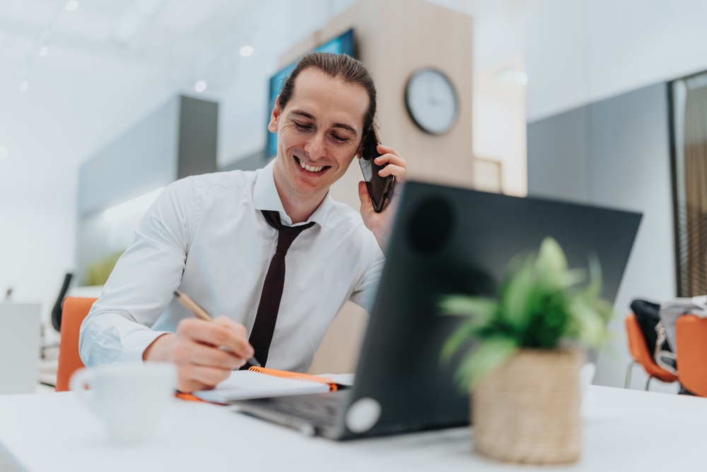 A,Smiling,Office,Worker,Sits,At,A,White,Desk,,Talking